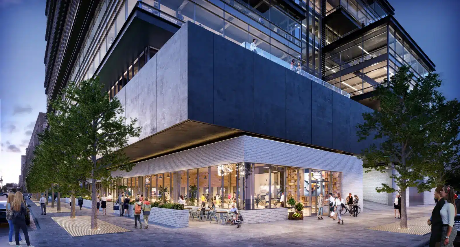 Evening street-level view of a vibrant office building with illuminated interiors