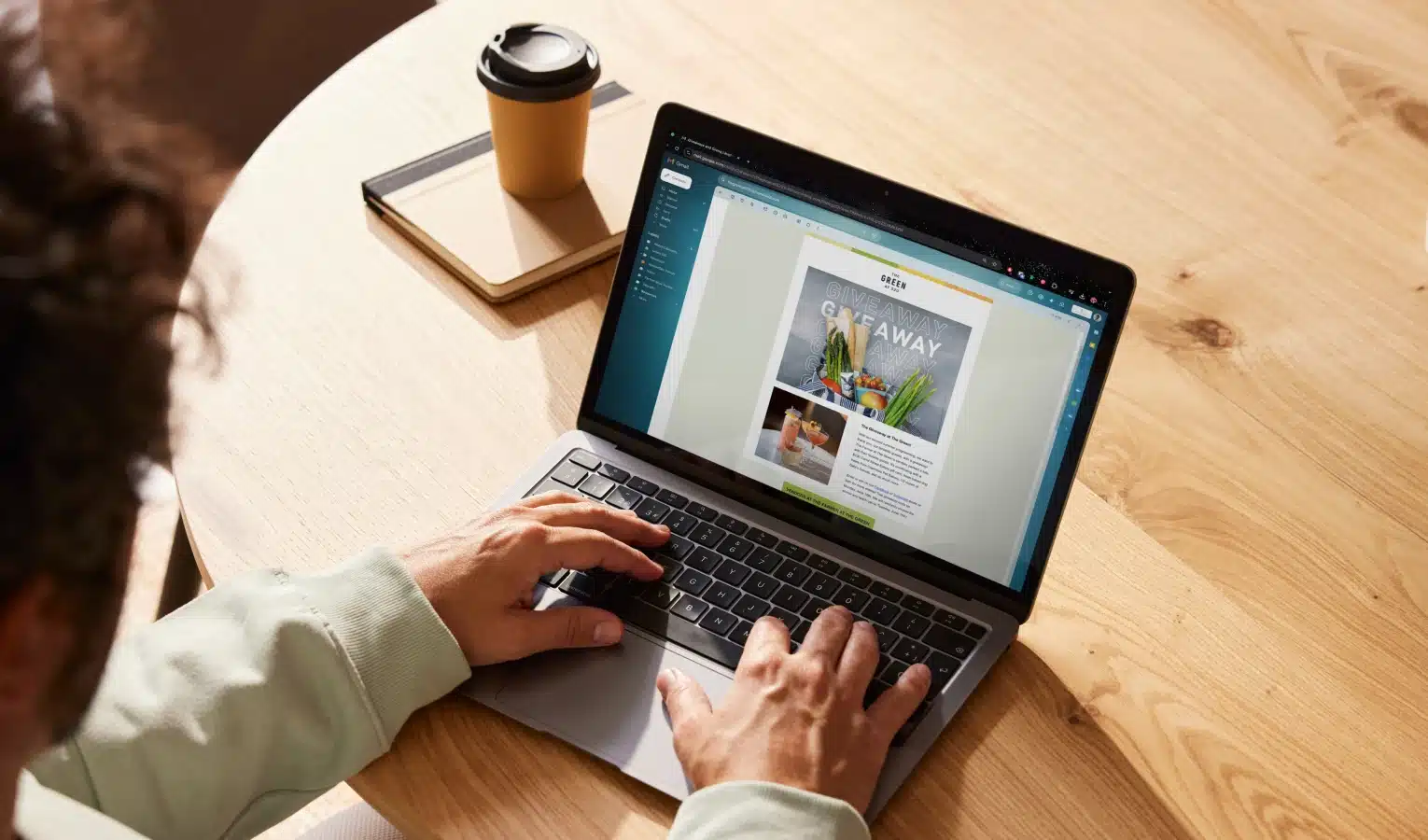 Overhead view of person using Canva on laptop to create digital flyer for The Green