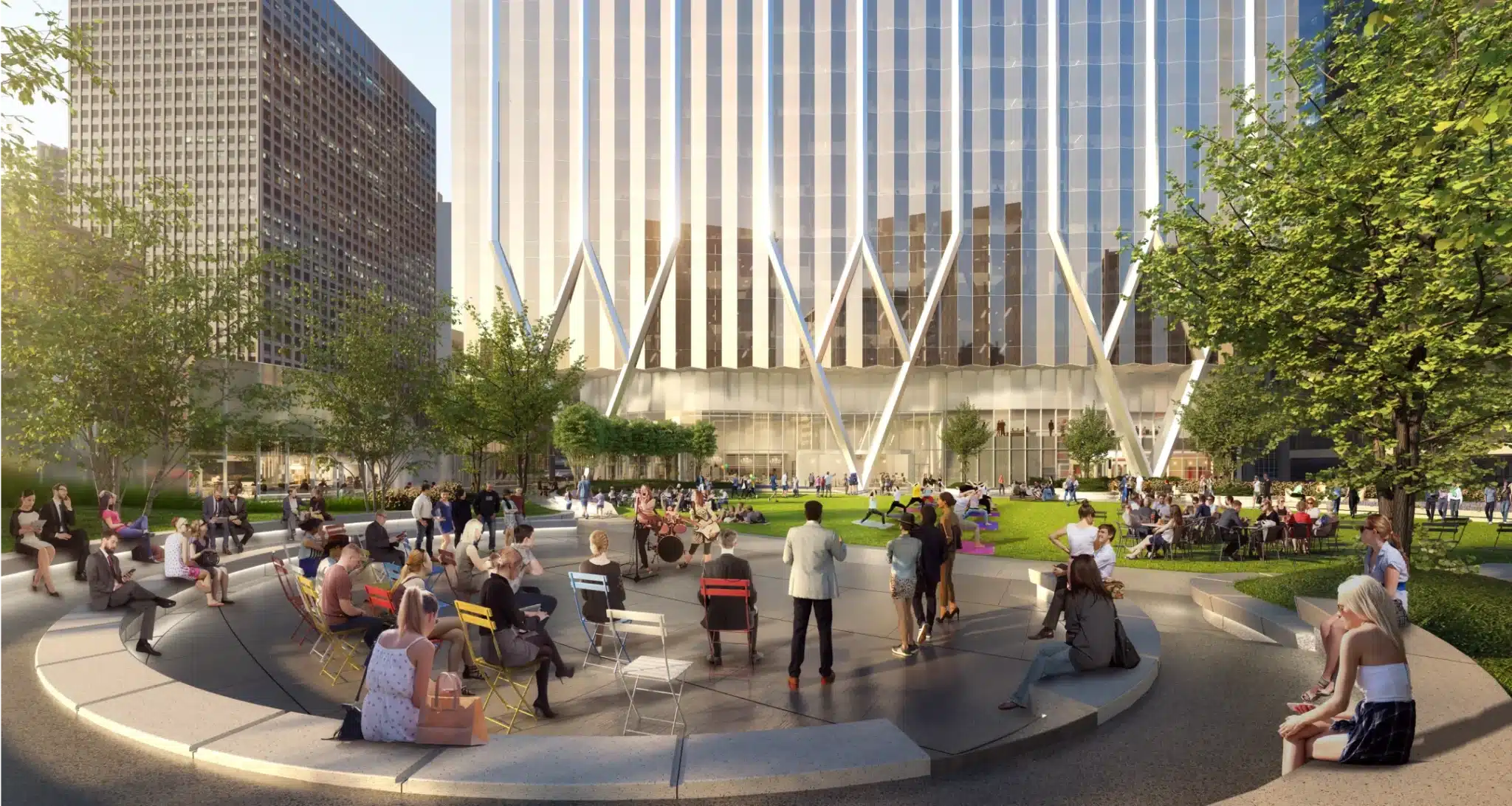 Outdoor concert gathering at The Green with diverse crowd seated near modern glass building