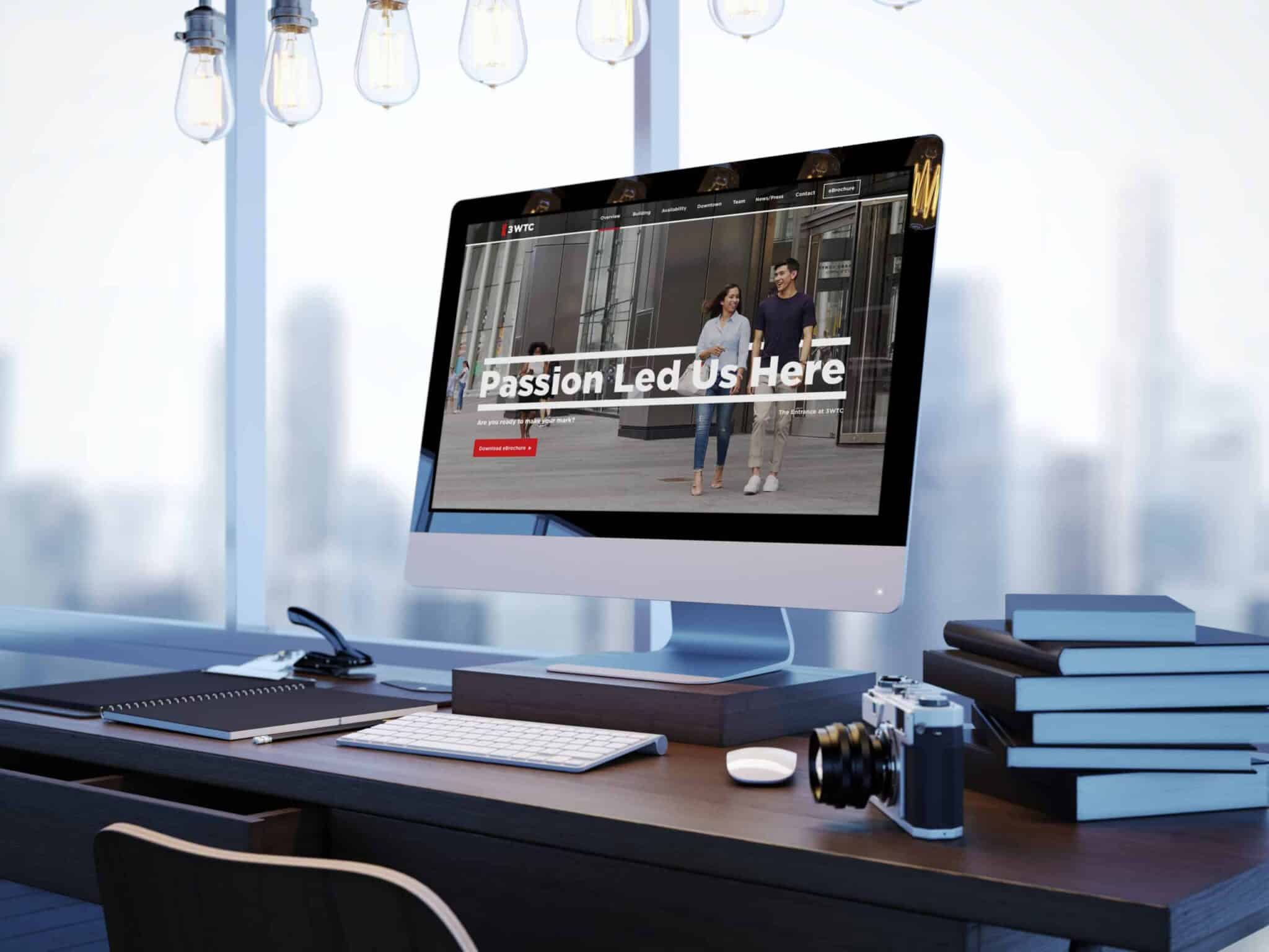 Modern office workspace featuring desktop with 3WTC website homepage reading: Passion Led Us Here